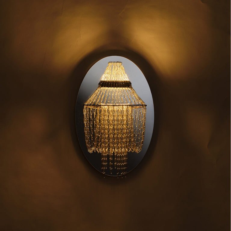 Gros plan sur les chaînes inox de l’applique Lampe C, reflets lumineux sans verre ni cristal