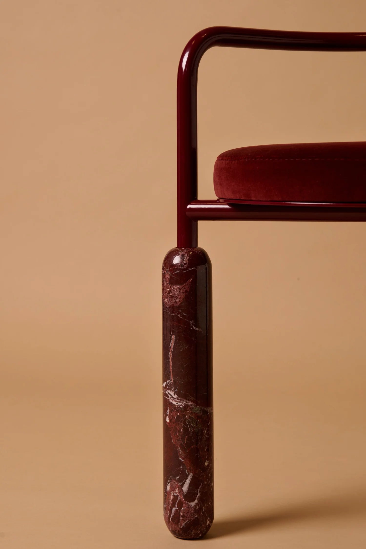 Detailed close‑up of Malmousque Bordeaux chair’s curved armrest and velvet seat by Michaël Koska